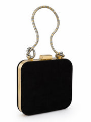 Back of the Midnight Crane Clutch in plain black fabric with a gold-trimmed frame and coiled metallic top handle.
