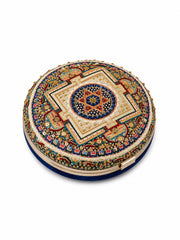 An ornate round clutch bag featuring intricate hand-embroidered geometric and floral mandala patterns in gold, blue, red, and green, with a dark blue velvet base, shown on a plain white background.