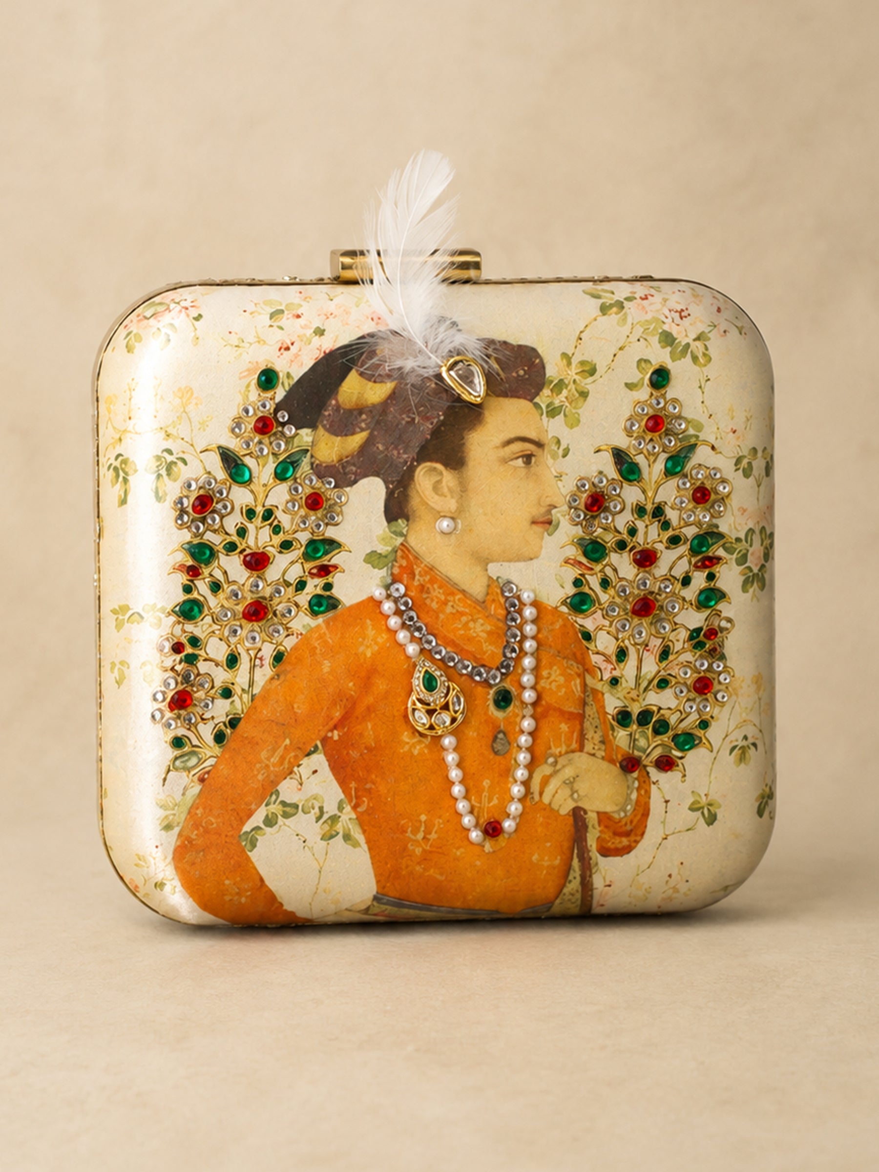 Front view of the Shahjahan Clutch, a square box clutch printed with a Mughal-style miniature portrait of a nobleman in an orange robe and jeweled turban with a white feather, flanked by gem-encrusted floral sprays, with a feather-topped clasp.
