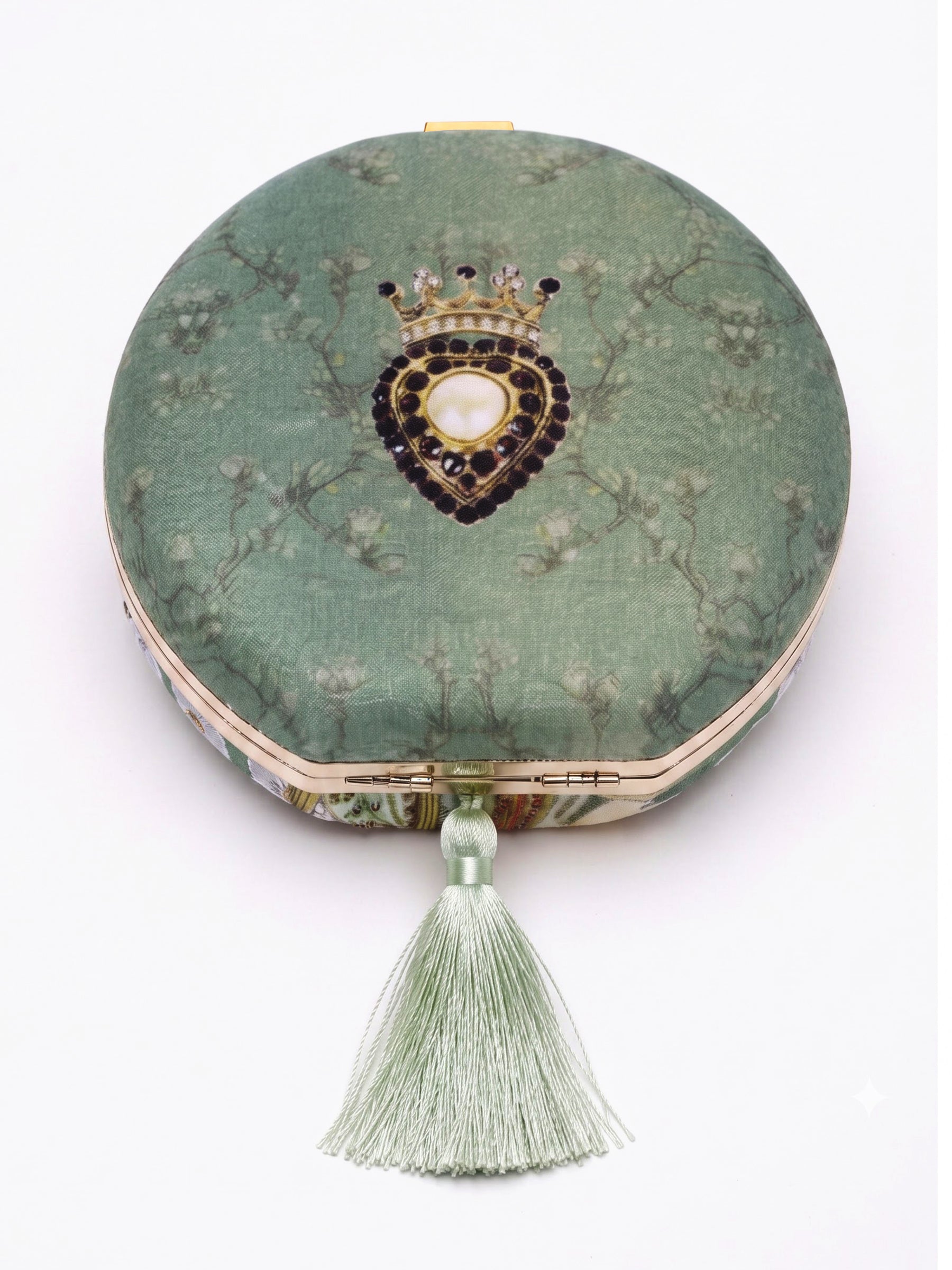 Back of the Raazdaar Embroidered Clutch showing the sage green floral-branch print, a beaded crown and heart medallion, and its silk tassel.