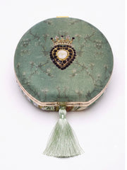 Back of the Raazdaar Embroidered Clutch showing the sage green floral-branch print, a beaded crown and heart medallion, and its silk tassel.
