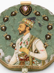 Close-up of the Raazdaar Embroidered Clutch's Mughal-style miniature portrait of a nobleman, framed by beaded crown medallions and a jeweled heart embellishment.