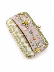 Angled top-down view of the Garden of Jewels Clasp Clutch showing the green paisley-patterned fabric, pink floral center band with pearl and crystal flower embellishments, and gold frame with clasp.