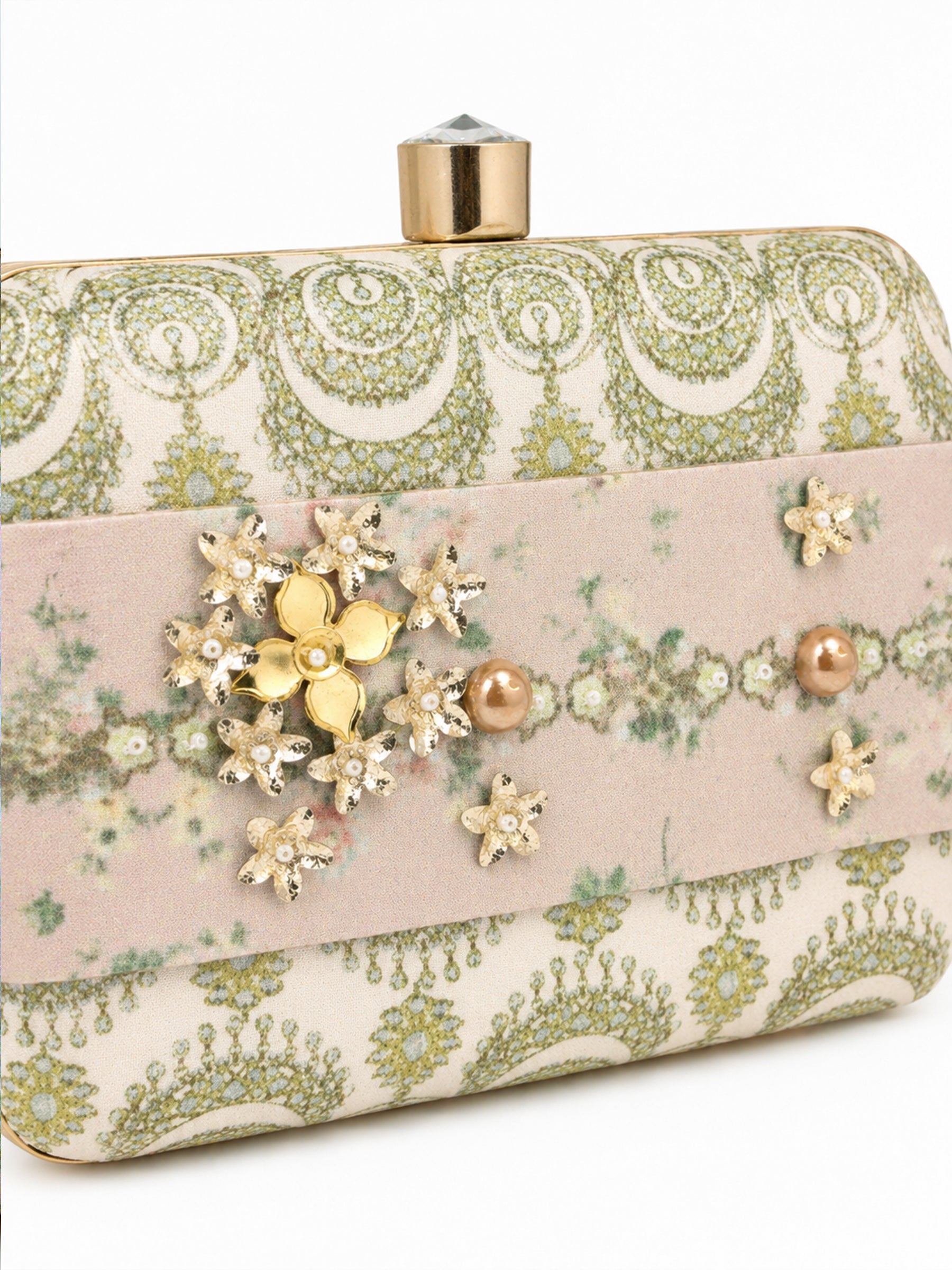 Close-up angled view of the Garden of Jewels Clasp Clutch showing the pink floral center band with detailed gold and pearl flower clusters and crystal accents, against the green paisley-patterned fabric side panels.