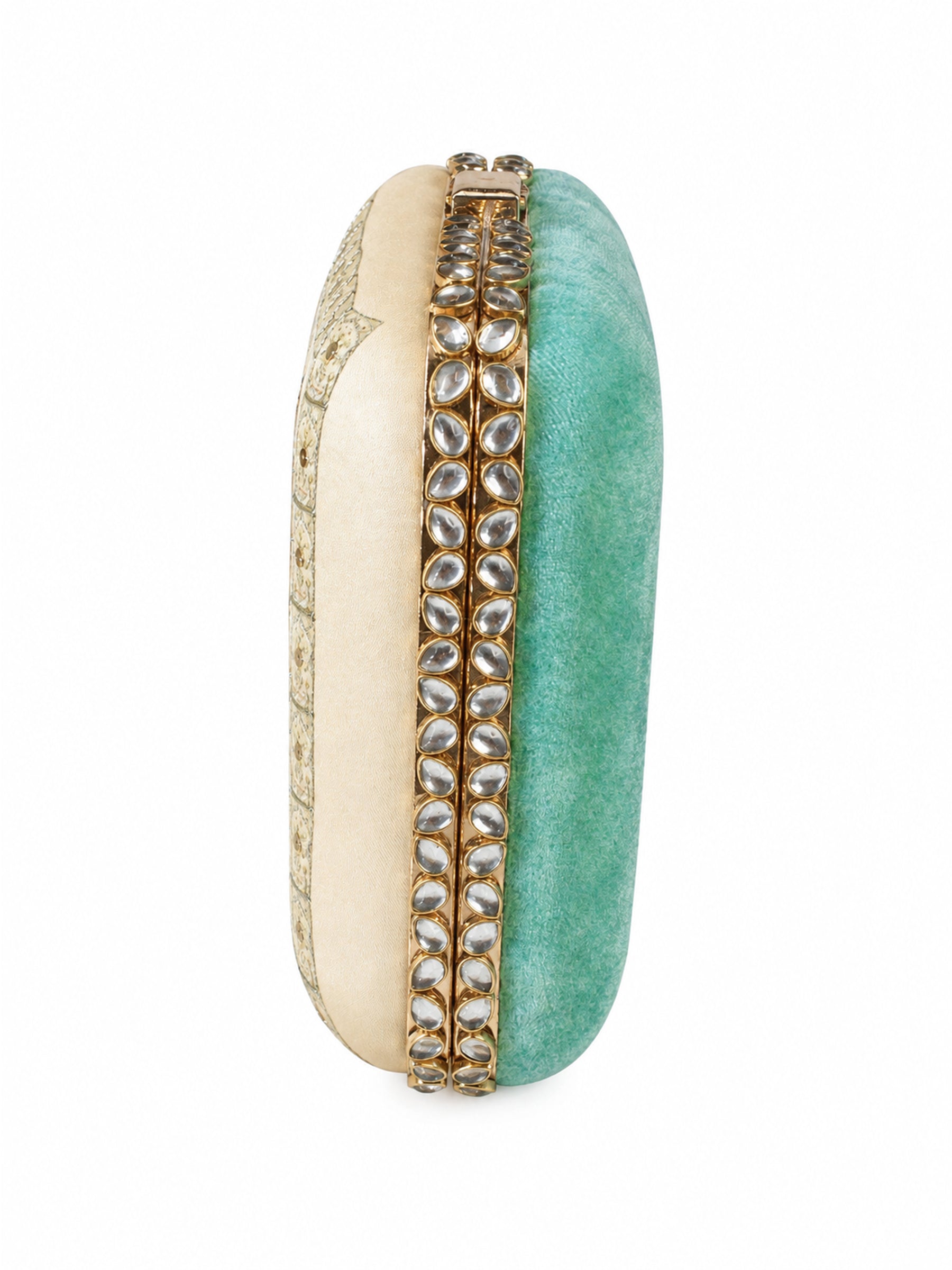 Side profile of the Saheliya Embroidered Clutch showing the cream gold-patterned panel and turquoise velvet panel divided by a row of crystal gemstones.