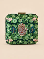 Hastkala Embroidered Clutch, a square box clutch in green fabric printed with lily pads and lotus flowers, centered with a beaded hand motif in gold, red, and white.