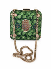 Front view of the Hastkala Embroidered Clutch with its gold chain strap coiled below, showing the beaded hand motif on the lily pad print.
