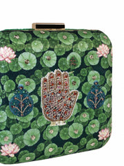 Close-up angled view of the Hastkala Embroidered Clutch highlighting the beaded hand motif surrounded by lily pads and lotus flowers.